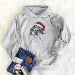 May include: A gray hoodie with a pocket features a black and white illustration of a German Shorthaired Pointer wearing a red Santa hat.