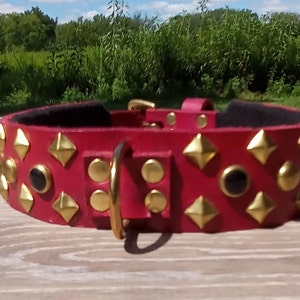 Red collar with brass pyramids with brass spots and black stones.