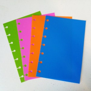 May include: Four different colored sheets of paper with punched holes along the side. The sheets are green, pink, orange, and blue.