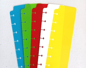 Può includere: Cinque divisori di pagine in plastica colorati con fori perforati per un planner a spirale. I divisori sono blu, verdi, rossi, bianchi e gialli.