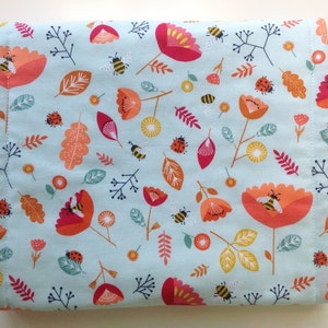 May include: A light blue fabric with a repeating pattern of red, orange, and yellow flowers, bees, and ladybugs.