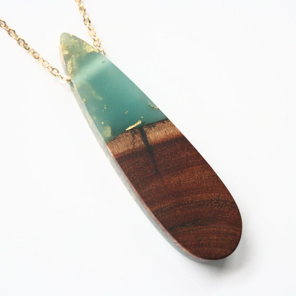 Long drop shaped pendant/ necklace handmade from teal blue resin with embedded gold leaf flakes and Australian wood. Made in Australia