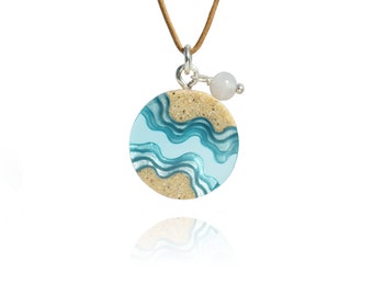 Collar Seaway- Collar redondo inspirado en la playa elaborado con arena y resina azul aguamarina con una piedra preciosa de ágata sobre cordón encerado marrón