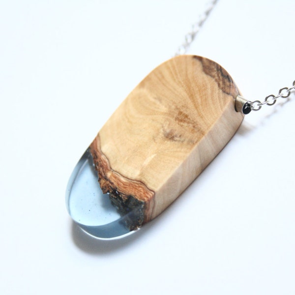 Handmade curved pendant from light blue resin and Australian Olive wood with a silver tone tube on a rhodium-plated chain. Made in Australia