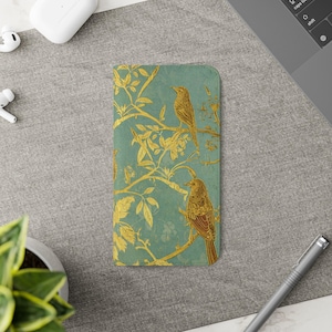 May include: A rectangular phone case featuring a teal background with a gold-colored illustration of two birds perched on branches among leaves. The design covers the entire surface of the case, showcasing a detailed, nature-inspired pattern.