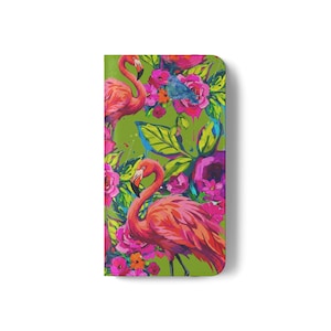May include: A rectangular phone case featuring a vibrant, painterly design of two pink flamingos surrounded by lush green foliage and bright magenta, red, and orange flowers. A small blue bird is nestled among the floral patterns on a green background.