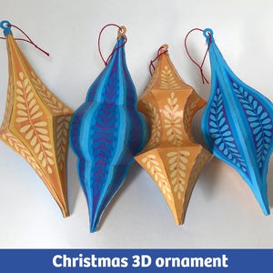 May include: Four 3D ornaments with pointed ends and hanging strings. Two ornaments are elongated with yellow and orange leaf patterns. Two ornaments have a rounded bulbous shape featuring blue and purple vertical stripes with leaf motifs.