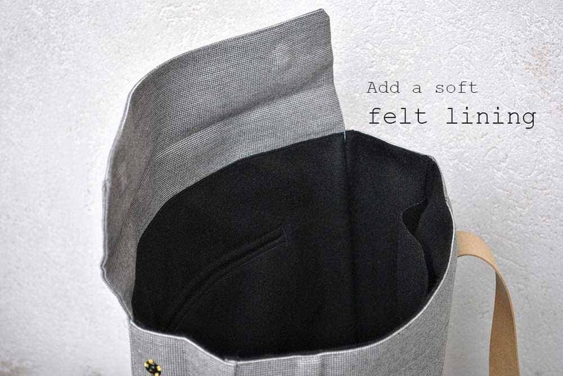 Interior of a gray backpack with black felt lining. It's written "add a soft felt lining".