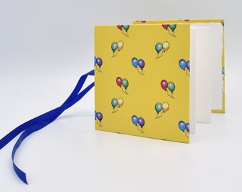 Handmade mini accordion album with multicolored balloons on yellow