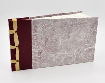 Handmade photo album with rice paper over burgundy background