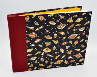 Handmade expandable scrapbook with colorful spaceships and rockets on black