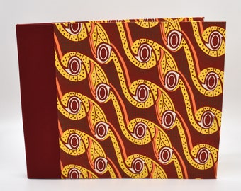 Handmade expandable scrapbook with red, yellow, and orange abstract shapes
