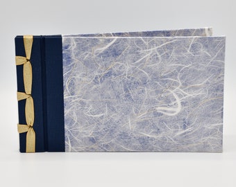 Handmade photo album with rice paper over blue background