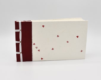Handmade photo album with small red hearts on a  white background
