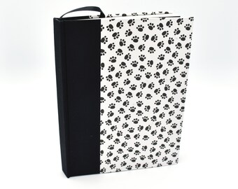 Handmade lined journal with black paw prints on white background