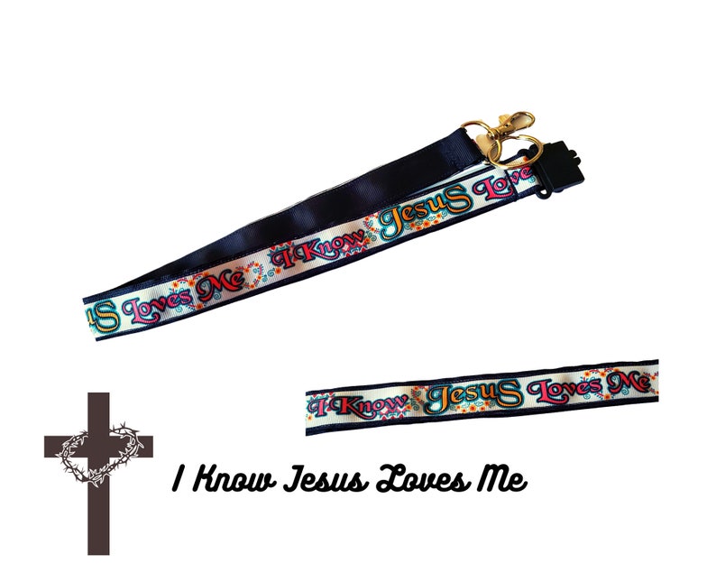 May include: A black and white lanyard with the text "I Know Jesus Loves Me" in colourful letters. The lanyard has a gold metal clasp and a black plastic swivel hook.