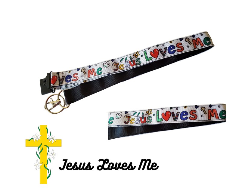 May include: White lanyard with black trim and a repeating pattern of "Jesus Loves Me" in colourful letters with a red heart. The lanyard has a metal key ring attached.