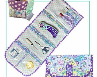 May include: A Gadget Girls Tool Kit and Snippet Bag, featuring a floral print design in purple, blue, and green. The kit includes a rotary cutter, scissors, and other sewing tools. The kit is designed by The Sweet Tea Girls Patterns.