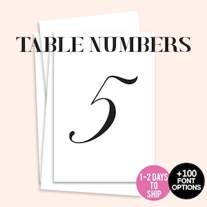 May include: White table number cards with the number 5 in a black, elegant font. The words "TABLE NUMBERS" are at the top. A pink circle states "1-2 DAYS TO SHIP" and a black circle states "+100 FONT OPTIONS".