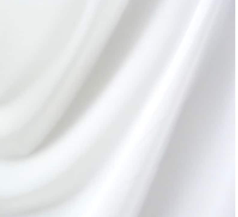 May include: White fabric with soft folds and wrinkles. The fabric is smooth and has a subtle sheen.