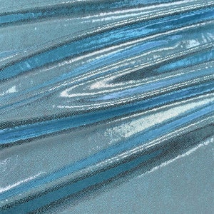 May include: A close-up of a light blue iridescent fabric with a textured, scaly pattern. The fabric is folded and draped, showing its shimmery and reflective surface.