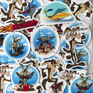 May include: A collection of cartoon stickers featuring the Wile E. Coyote character in various poses. The stickers depict the coyote with TNT, holding a "HELP!" sign, and in scenes with the Road Runner. The stickers have a white border and a blue background.