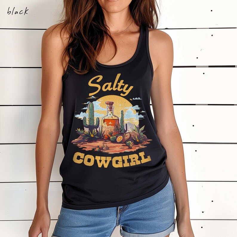 K&ouml;nnte beinhalten: Schwarzes Tanktop mit einem W&uuml;sten-Themen-Grafik. Die Grafik zeigt eine Flasche Schnaps, Kakteen und die Worte "Salty Cowgirl" in Gelb. Das Tanktop ist &auml;rmellos und hat ein Racerback-Design.