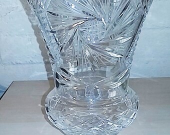 May include: A clear glass vase with a cut crystal design. The vase has a wide mouth and a round base.