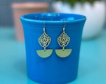 May include: A pair of gold-toned earrings with a filigree design and a half-circle pendant.