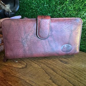 Cartera Buxton de piel color burdeos oscuro para mujer con cierre de cremallera y tarjetero para chequera