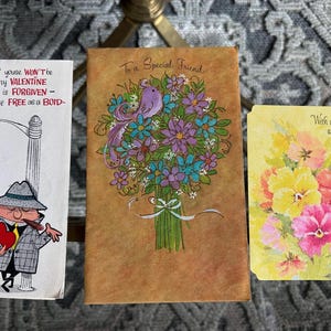 May include: Three vintage greeting cards. The first card features a cartoon man in a hat holding a heart and a cigar. The text on the card reads "If youse WON'T'be my VALENTINE All is FORGIVEN - You're FREE as a BOID-". The second card features a bouquet of flowers with a bird and the text "To a Special Friend". The third card features a bouquet of flowers and the text "With a Prayer at Easter".