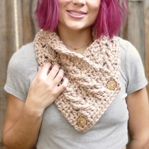 Elegant crochet cable button scarf made with super bulky yarn for warmth and rich texture. Features classic cable stitches and decorative buttons for a cozy, stylish finish. Shown in soft neutral tones, perfect for layering during fall and winter. Quick and easy PDF crochet pattern for beginners and advanced makers. A beautiful handmade cowl or neck warmer ideal for gifts, markets, or personal winter wear.