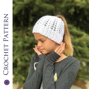 Puede incluir: Sombrero blanco de ganchillo con un agujero en la parte posterior para una coleta.