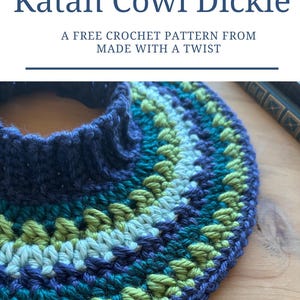 May include: A close-up of a blue, green, and white crocheted cowl neck. The cowl is made with a textured stitch and has a simple, elegant design. The text "Quick and Easy Katan Cowl Dickie" is displayed above the image. The text "A FREE CROCHET PATTERN FROM MADE WITH A TWIST" is displayed below the image.