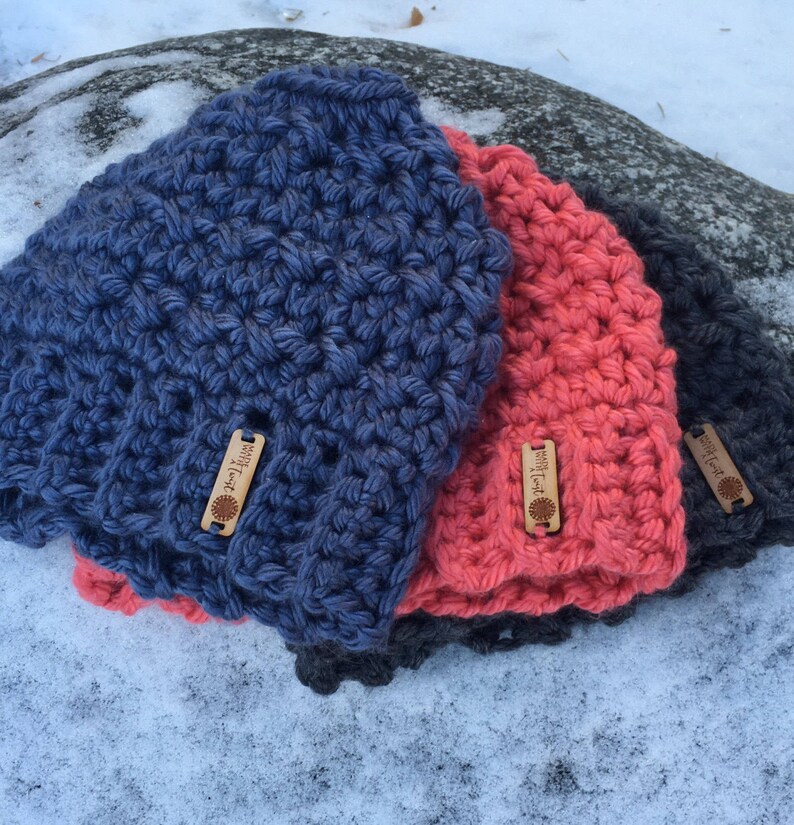 Peut inclure: Trois bonnets en crochet de diff&eacute;rentes couleurs&nbsp;: bleu, corail et gris. Chaque bonnet est dot&eacute; d&rsquo;une petite &eacute;tiquette en bois sur laquelle est inscrit le texte &laquo;&nbsp;Made with Love&nbsp;&raquo;.