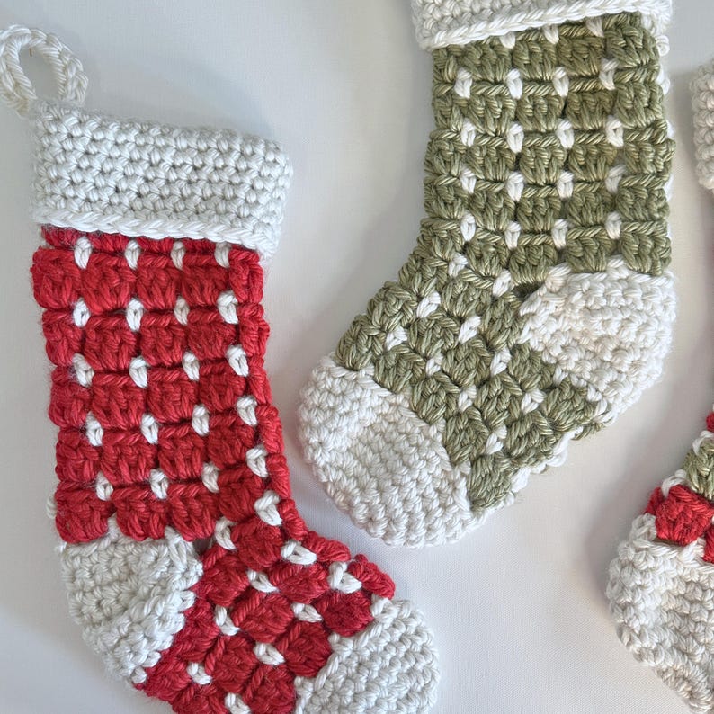 Chunky crochet Christmas stocking made with super bulky yarn for a cozy farmhouse holiday look. Features thick textured stitches and a wide hanging loop for easy display on mantels or stair rails. Shown in neutral tones for rustic, modern Christmas decor. Quick and easy PDF crochet pattern perfect for beginners and experienced makers. A timeless handmade stocking for festive home décor or thoughtful holiday gifting.