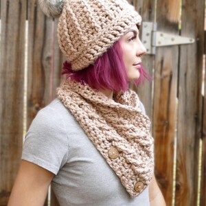 Elegant crochet cable button scarf made with super bulky yarn for warmth and rich texture. Features classic cable stitches and decorative buttons for a cozy, stylish finish. Shown in soft neutral tones, perfect for layering during fall and winter. Quick and easy PDF crochet pattern for beginners and advanced makers. A beautiful handmade cowl or neck warmer ideal for gifts, markets, or personal winter wear.