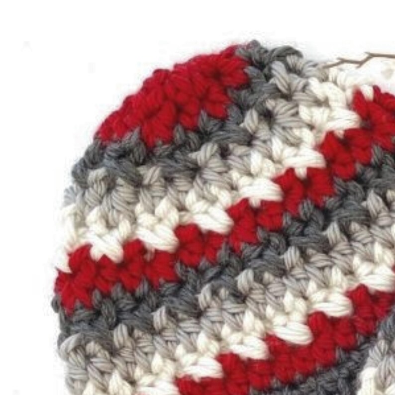 Peut inclure: Gros plan sur un chapeau crochet&eacute; avec des rayures rouges, blanches et grises.