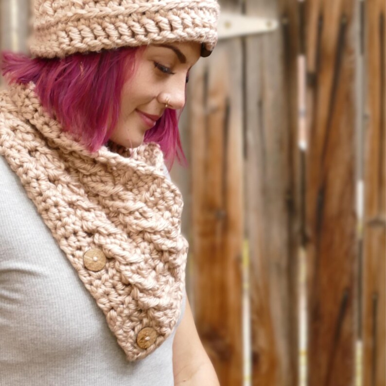 Elegant crochet cable button scarf made with super bulky yarn for warmth and rich texture. Features classic cable stitches and decorative buttons for a cozy, stylish finish. Shown in soft neutral tones, perfect for layering during fall and winter. Quick and easy PDF crochet pattern for beginners and advanced makers. A beautiful handmade cowl or neck warmer ideal for gifts, markets, or personal winter wear.