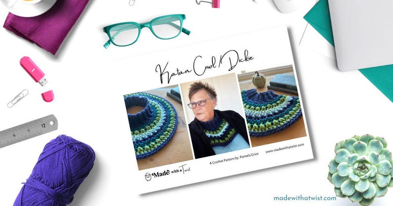 May include: A crochet pattern for a Katan cowl and dickey, featuring a blue, green, and white color scheme. The pattern is by Pamela Grace and is available on the website madewithatwist.com.