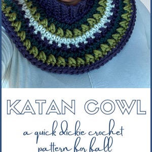May include: A crocheted cowl in shades of green, blue, and purple. The cowl is a quick and easy crochet pattern for fall. The text "KATAN COWL" is displayed above the cowl, and the text "a quick dickie crochet pattern for fall" is displayed below the cowl. The text "A FREE CROCHET PATTERN FROM MADEWITHATWIST.COM" is displayed at the bottom of the image.