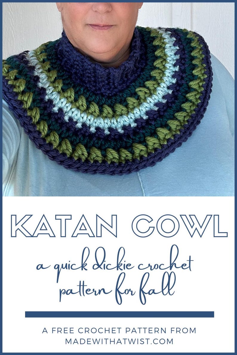 May include: A crocheted cowl in shades of green, blue, and purple. The cowl is a quick and easy crochet pattern for fall. The text "KATAN COWL" is displayed above the cowl, and the text "a quick dickie crochet pattern for fall" is displayed below the cowl. The text "A FREE CROCHET PATTERN FROM MADEWITHATWIST.COM" is displayed at the bottom of the image.