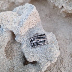 May include: Silver pendant featuring the Eye of Horus, an ancient Egyptian symbol of protection and good health. The pendant is rectangular and has a detailed design.