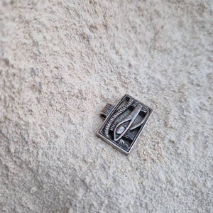 May include: Silver pendant featuring an intricate design of the Eye of Horus, a symbol of protection and good health in ancient Egyptian culture.