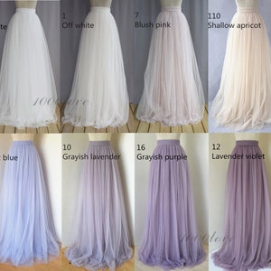 May include: A collage of ten tulle skirts in various colors, including white, off-white, blush pink, shallow apricot, soft blue, grayish lavender, grayish purple, and lavender violet. Each skirt has a waistband and is made of a soft, flowing fabric.