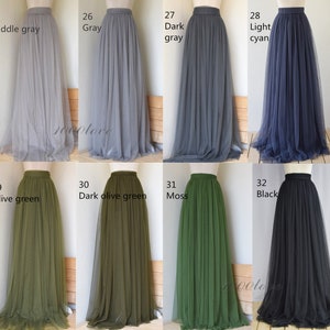 May include: Eight tulle skirts in various colors, including gray, light cyan, olive green, dark olive green, moss green, and black. The skirts are all full-length and have a high waist.