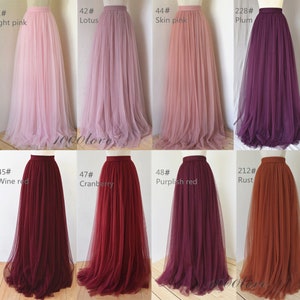 May include: Eight tulle skirts in different colors, including light pink, lotus, skin pink, plum, wine red, cranberry, purplish red, and rust. The skirts are all full-length and have a gathered waistband.