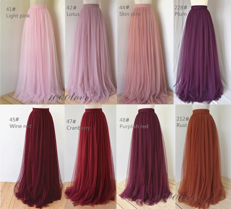 May include: Eight tulle skirts in different colors, including light pink, lotus, skin pink, plum, wine red, cranberry, purplish red, and rust. The skirts are all full-length and have a gathered waistband.