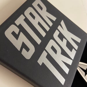 May include: A black box with the words "STAR TREK" printed in silver lettering.