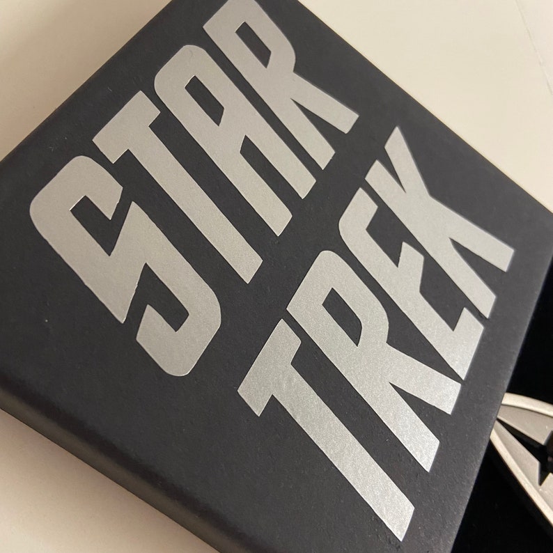 May include: A black box with the words "STAR TREK" printed in silver lettering.